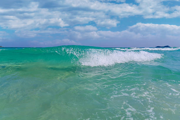 istock Smal green ocean wave with cloudy sky background 1367004182