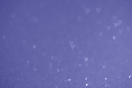 Trendy very peri color of the year 2022, violet blue hearts, sparkling glitter bokeh background, valentines day abstract defocused texture
