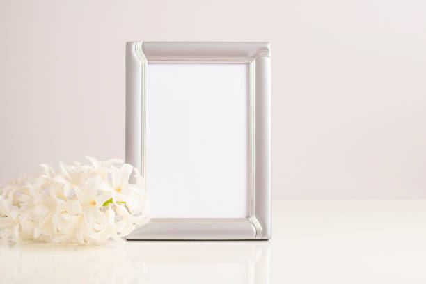 istock Mockup photo frame with a beautiful white hyacinth flower on the table. 1367007299