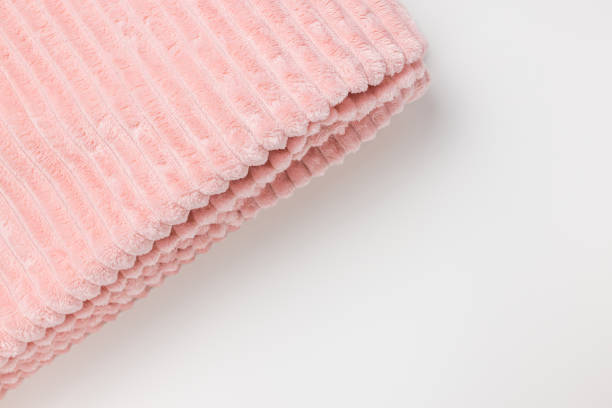istock New folded pink throw fleece fabric with lines on white background, closeup 1367007427