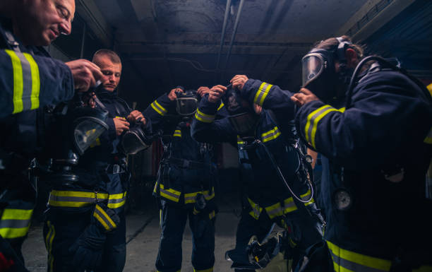 istock Group of firefighters standing inside the fire brigade wearing helmet and protective uniform 1367007755