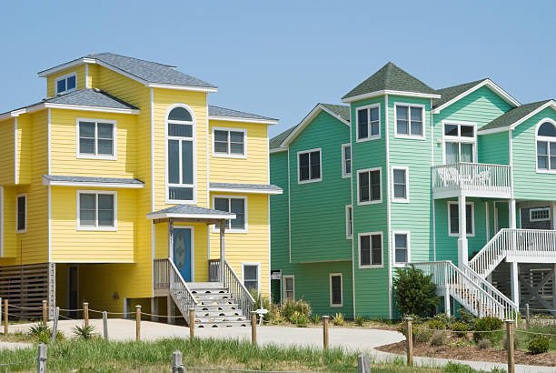 Beach Houses in Bright Colors at Seaside Resort Beach houses in unusual bright colors at a summer seaside resort, Victorian architectural style in new buildings, Outer Banks in North Carolina, NC, USA. outer banks north carolina stock pictures, royalty-free photos & images