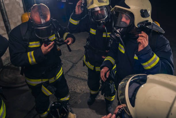 istock Group of firefighters standing inside the fire brigade wearing helmet and protective uniform 1367008598
