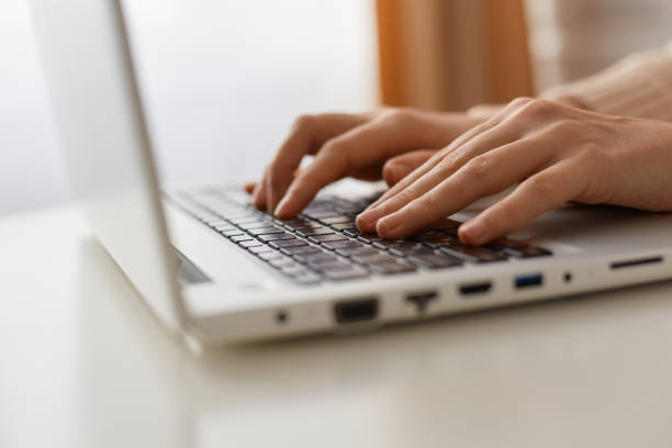 istock Indoor shot of faceless unknown anonymous woman typing text on keyboard on laptop, programming, doing her online work on portable notebook. 1367008809