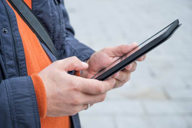 istock Cropped picture of an unrecognizable man using a tablet in the city 1367009062