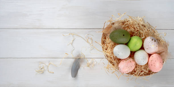 istock Easter eggs in a basket on a white wooden table, top view, copy space 1367010612