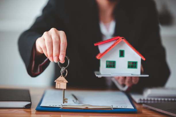 istock Real estate agent with house plans and keys in hand. 1367011780