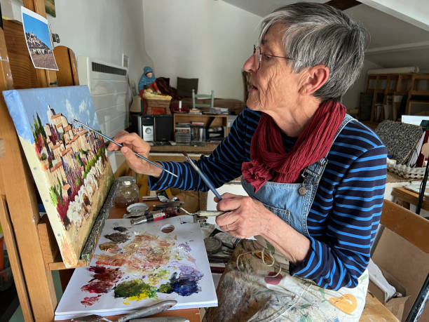 istock Active senior woman painting a landscape 1367013780