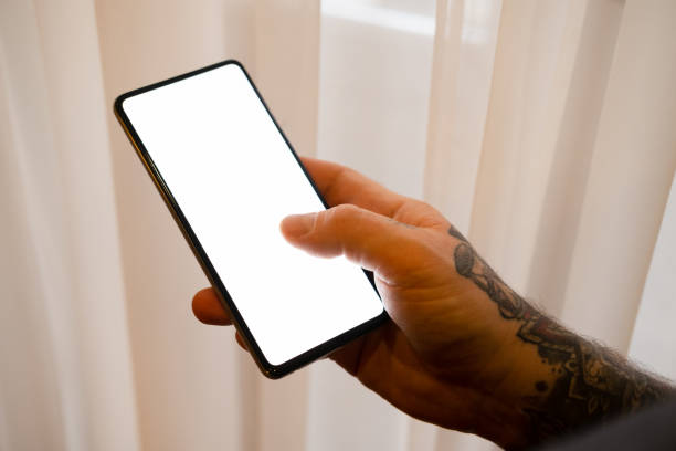 istock Candid photo of a man using mobile phone next to a window. 1367015039