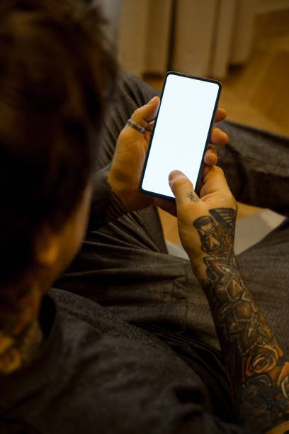 istock Candid photo of a man using mobile phone in a room. 1367015059
