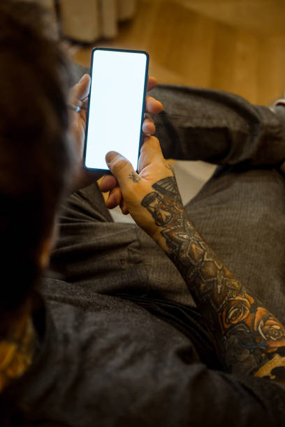 istock Candid photo of a man using mobile phone in a room. 1367015065