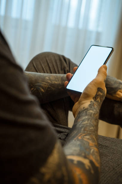 istock Candid photo of a man using mobile phone in a room. 1367015068