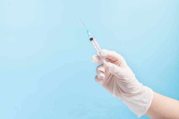 istock Hand with syringe. Making injection with copy space. Hand holding dose of vaccine. 1367015353