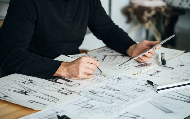istock An Anonymous Designer Working on a Digital Tablet and Blueprints at his Office 1367015543