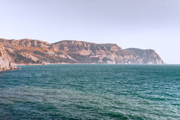 A distant steep rocky mountain on the Black sea shore A distant steep rocky mountain on the Black sea shore near the time of sunset black sea stock pictures, royalty-free photos & images