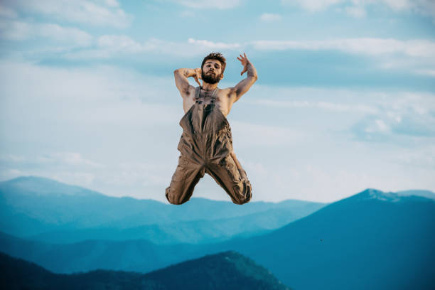 istock Positive young man is dancing over blue sky 1367015706