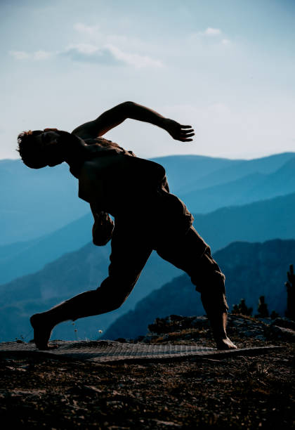 istock Young handsome dancer in beige overall dancing on mountain peak 1367015717