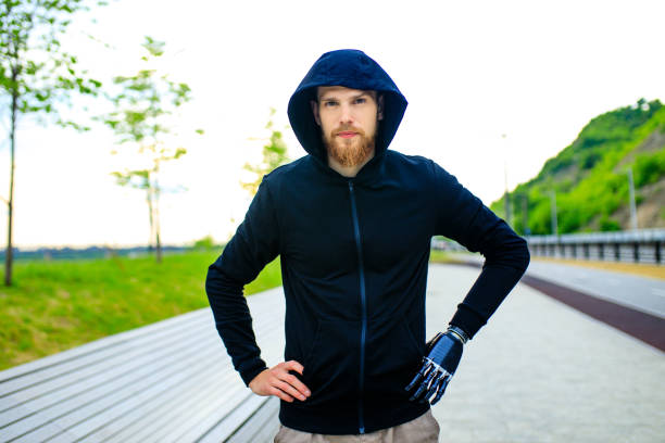 man with arm prosthesis in sports clothing ready for morning workout outdoors. Disabled sport concept man with arm prosthesis in sports clothing ready for morning workout outdoors. Disabled sport concept. paralympic games stock pictures, royalty-free photos & images