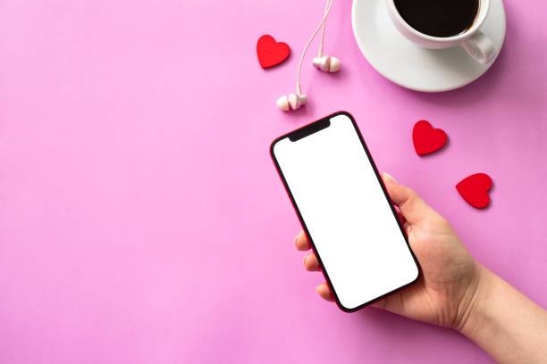 istock Valentine's day concept, mobile phone in hand blank screen with red hearts on pink background. Love in social media 1367015943
