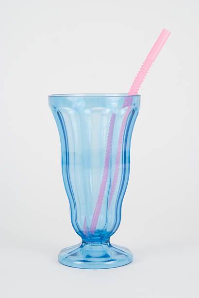 Macro closeup of iced tea or soda with ice cubes and straw in glass