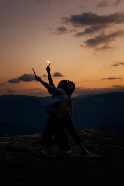 istock Handsome man holding firecrackers and dancing with a slim, attractive girl 1367016585