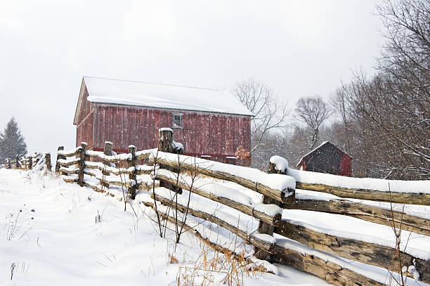 istock Red Barn and Rail Fence in Falling Snow 136701741