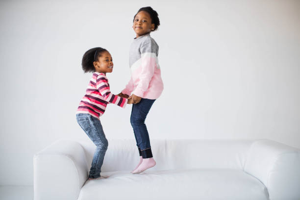 istock Pretty african american children jumping together on sofa 1367018172