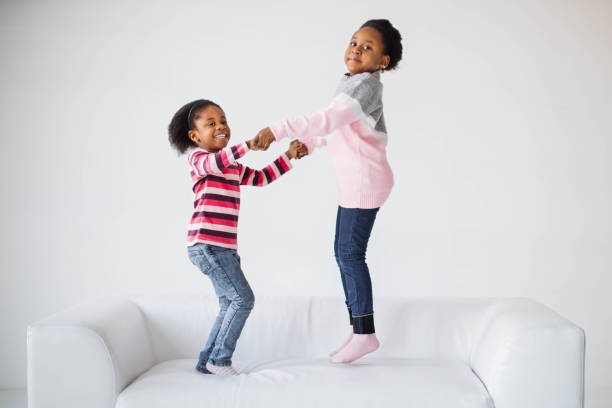 istock Pretty african american children jumping together on sofa 1367018178