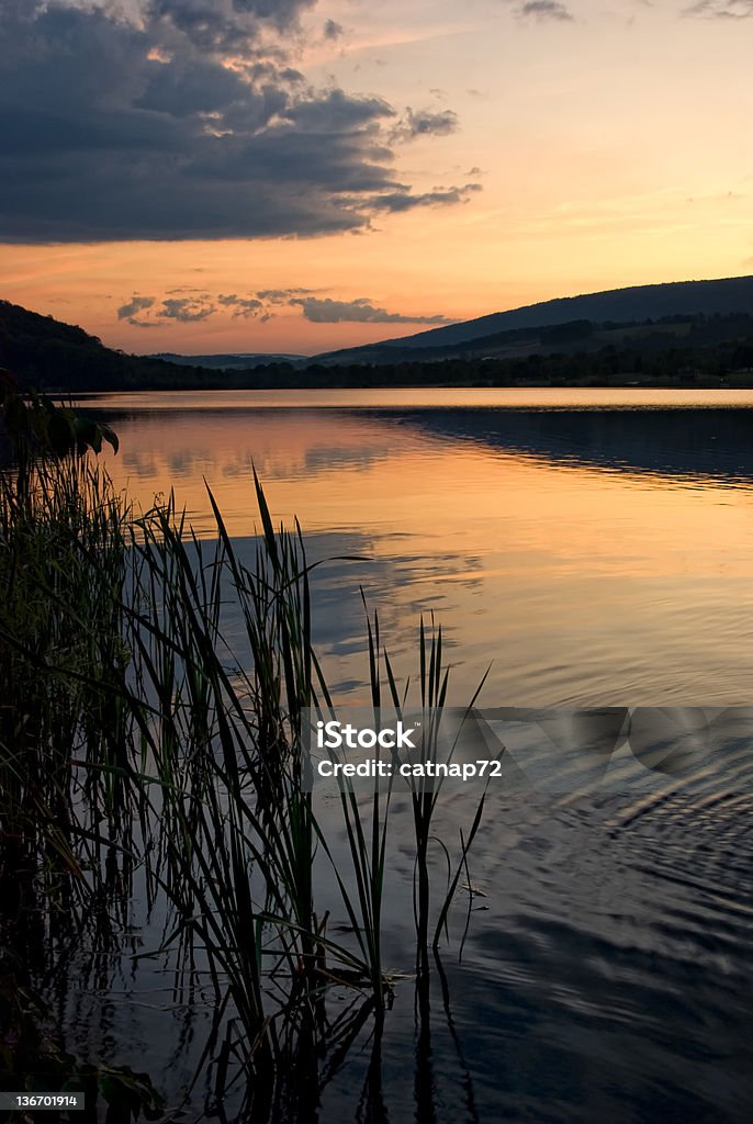 Arancio tramonto sul lago con sfondo di montagna - Foto stock royalty-free di Acqua