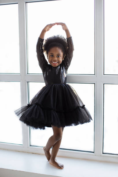 istock aAfrican female kid in ballet pose standing on windowsill 1367021763