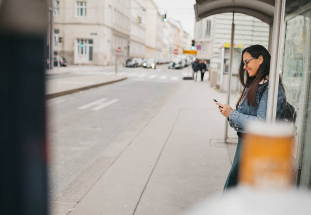 istock A woman is waiting for a bus at a stop 1367022764