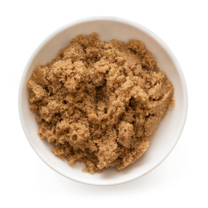Bowl of brown sugar, isolated on white.  Overhead view.