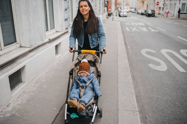 istock Mother pushing a stroller in the street 1367023686