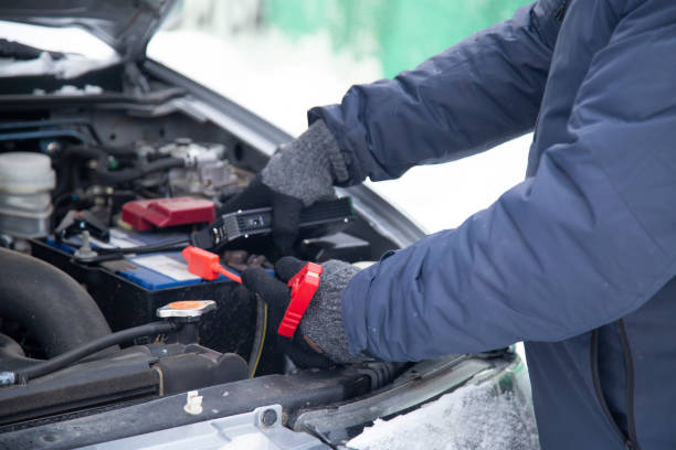 Jumper starter. Jumper starter.We start the car in a severe frost on the street. car battery stock pictures, royalty-free photos & images