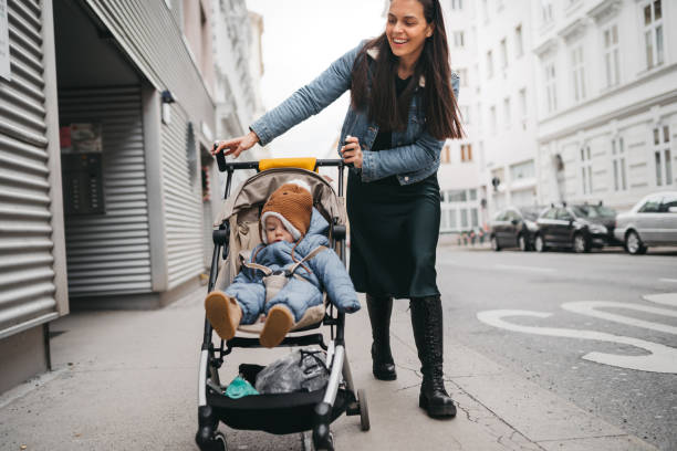 istock Mother pushing a stroller in the street 1367024128