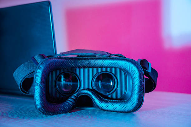 istock Virtual reality glasses and laptop with colored backgrounds 1367025963