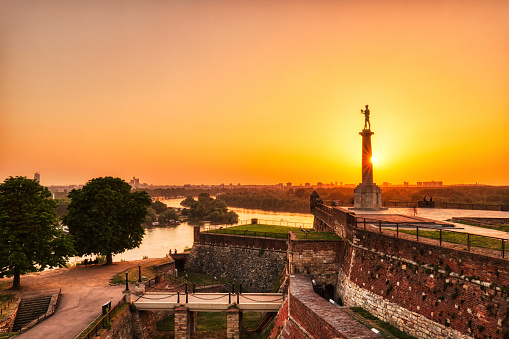 Kalemegdan Fortress and Victor Monument at Sunset, Belgrade, Serbia                Keywords:                     kalemegdan, fortress, belgrade, danube, landmark, serbia, city, skyline, monument, exterior, dusk, sunset, sunrise, river, travel, culture, standing, boat, outdoor, urban, attraction, balkan, sculpture, architecture, column, victory, europe, place, terrace, national, tourism, destination, panorama, victor, symbol, historical, castle, capital, building, beograd, sky, town, sightseeing, old, statue, ancient, yugoslavia, serbian, mestrovic
