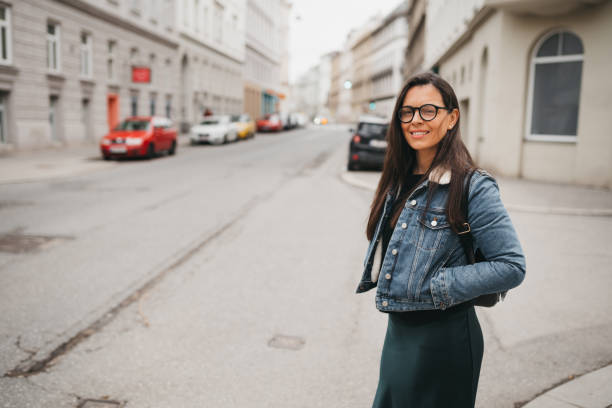 A woman is waiting for a bus at a stop
