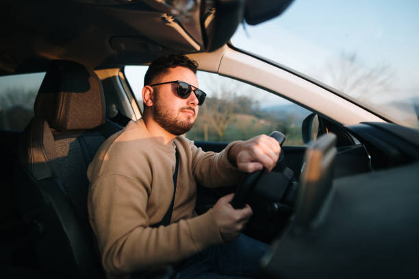 istock Young man driving a car 1367028688