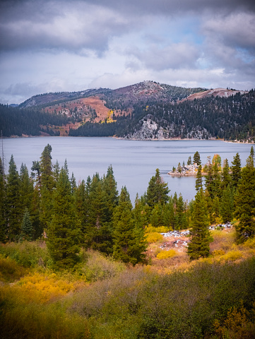 A high elevation, Backcountry, lake near Lake Tahoe called Marlette Lake is surrounded by vibrant fall colors and a light dusting of fresh snow.