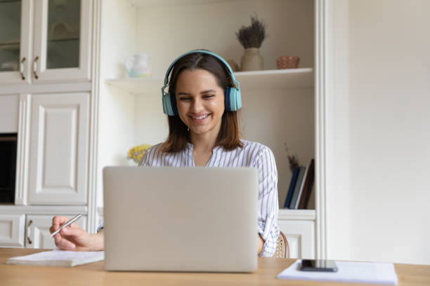 istock Cheerful student girl in bright wireless headphones watching learning webinar 1367031441