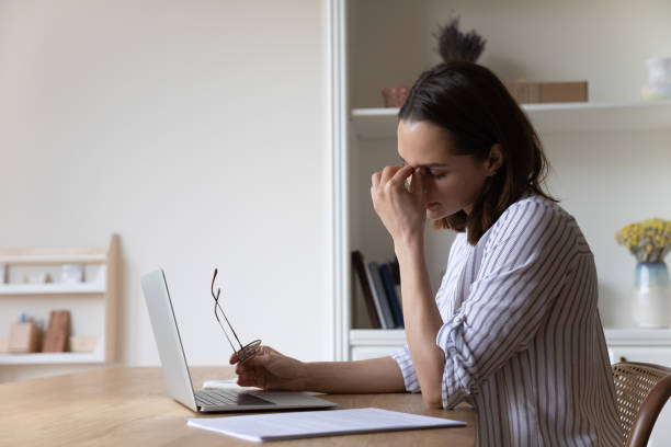 istock Tired employee woman working at laptop computer too long 1367031443
