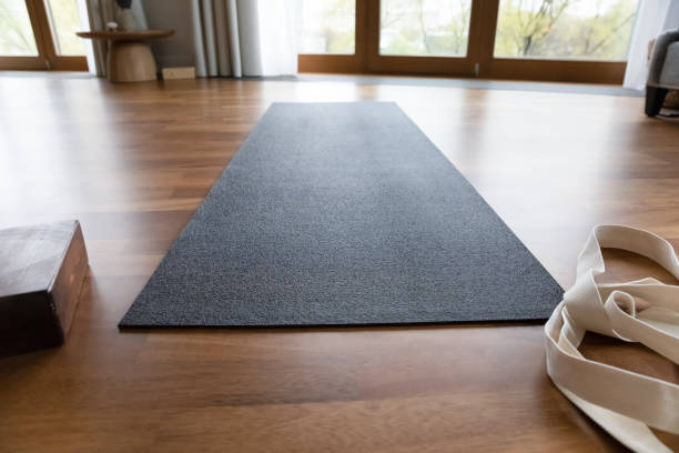 istock Dark grey yoga mat and strap in empty room 1367031976