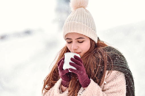 Beautiful Female With Snow Cap Enjoying Warm Coffee In Mountain Snow