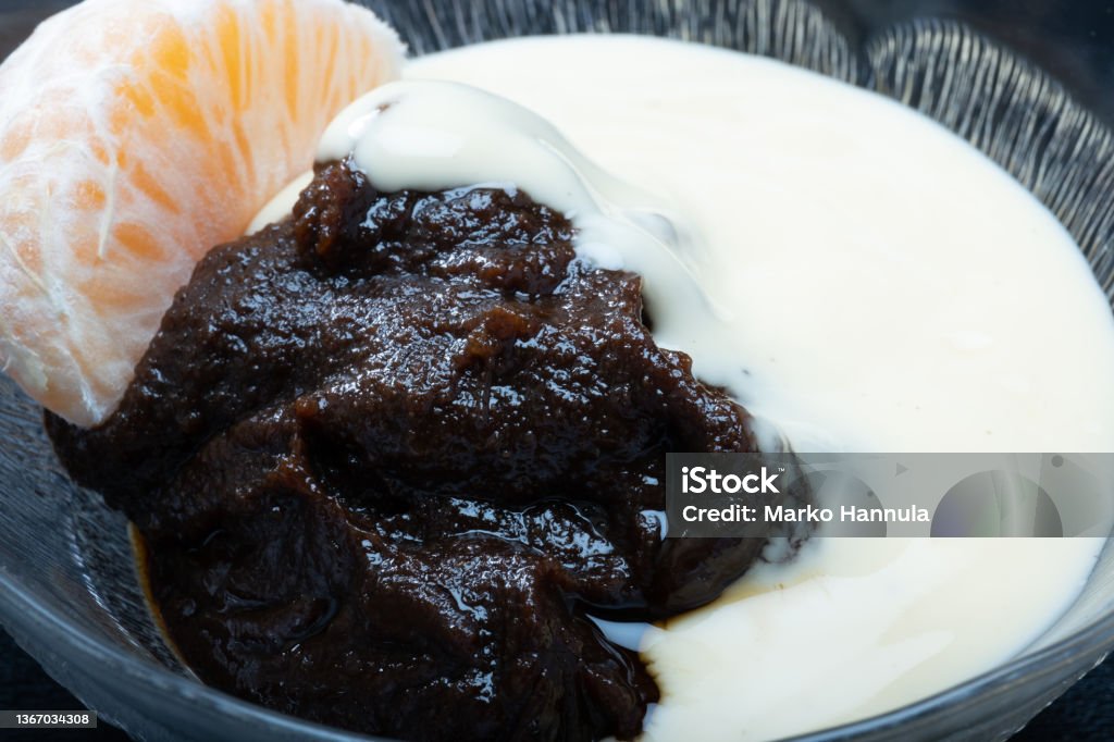 Traditional Finnish cuisine - Typically rye based Mämmi is eaten around Easter with fresh cream or custard. Helsinki / Finland - JANUARY 23, 2022: Traditional Finnish cuisine - Typically rye based Mämmi is eaten around Easter with fresh cream or custard. Easter Stock Photo