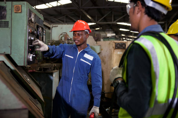 istock male african foreman training and teaching how to use machine control with workers in factory 1367034749