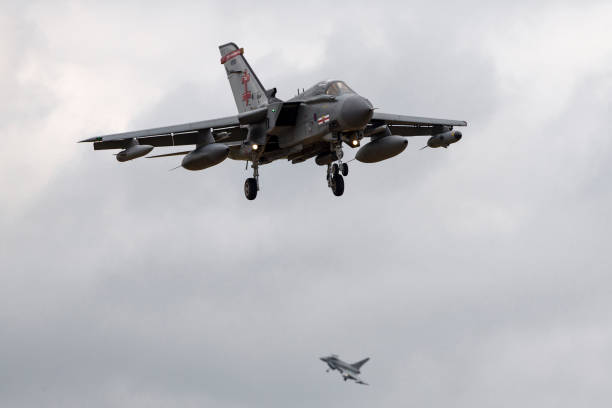 Royal Air Force (RAF) Panavia Tornado on approach to land at Waddington. Lincolnshire, UK - July 4, 2014: Royal Air Force (RAF) Panavia Tornado GR4 ZA600 from No.41(R) Squadron on approach to land at Waddington with a Eurofighter Typhoon in the background. raf stock pictures, royalty-free photos & images