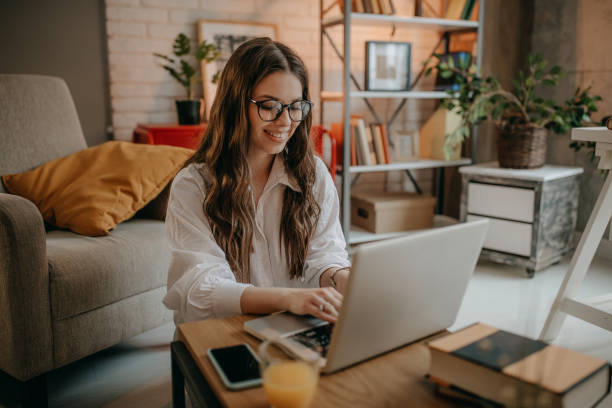 istock Young woman using laptop at home 1367038858