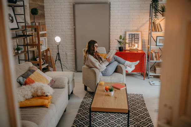 istock Woman reading a book at home 1367038987