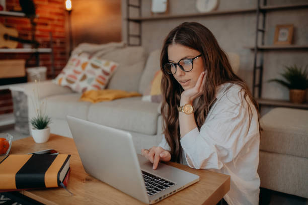 istock Young woman using laptop at home 1367039106